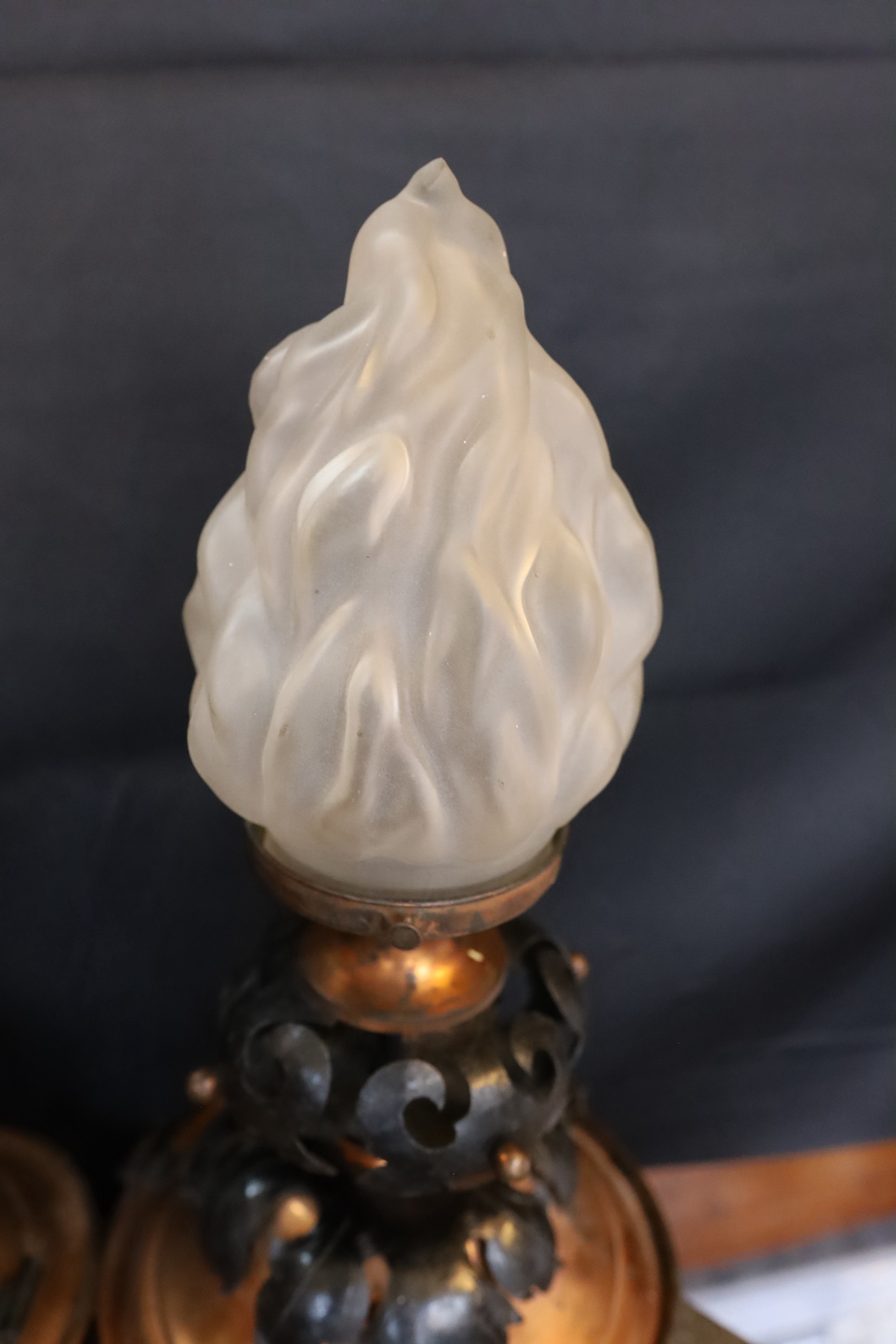 A pair of French Arts & Crafts copper and wrought iron ceiling lights with flambeau frosted glass shades, height 37cm. width 21cm